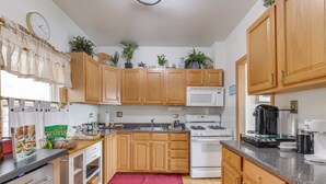 A kitchen with wooden cabinets, a microwave, stove, and various appliances. - Pet Friendly: 8 Mi to Chicago - Fenced Backyard! (Oak Park)