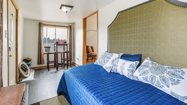 A bedroom with a large bed, a desk, and a chair. - Pet Friendly: 8 Mi to Chicago - Fenced Backyard! (Oak Park)