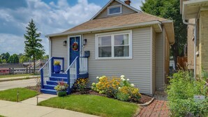 A single-story house with a front porch, a small garden with flowers, and a clear sky. - Pet Friendly: 8 Mi to Chicago - Fenced Backyard! (Oak Park)