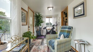 A hallway with a view to the outside, a chair, a table with books, a plant, and a bicycle. - Pet Friendly: 8 Mi to Chicago - Fenced Backyard! (Oak Park)