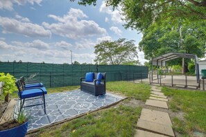An outdoor patio with a patterned mat, a bench with blue cushions, and a covered seating area. - 8 Mi to Chicago! Near Oak Park Attractions (Oak Park)