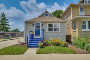 A two-story house with a front porch, a visible mailbox, and a small garden with various plants and flowers. - 8 Mi to Chicago! Near Oak Park Attractions (Oak Park)
