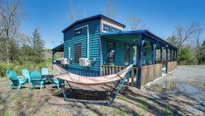 A cabin with a porch, outdoor seating, and a hammock.