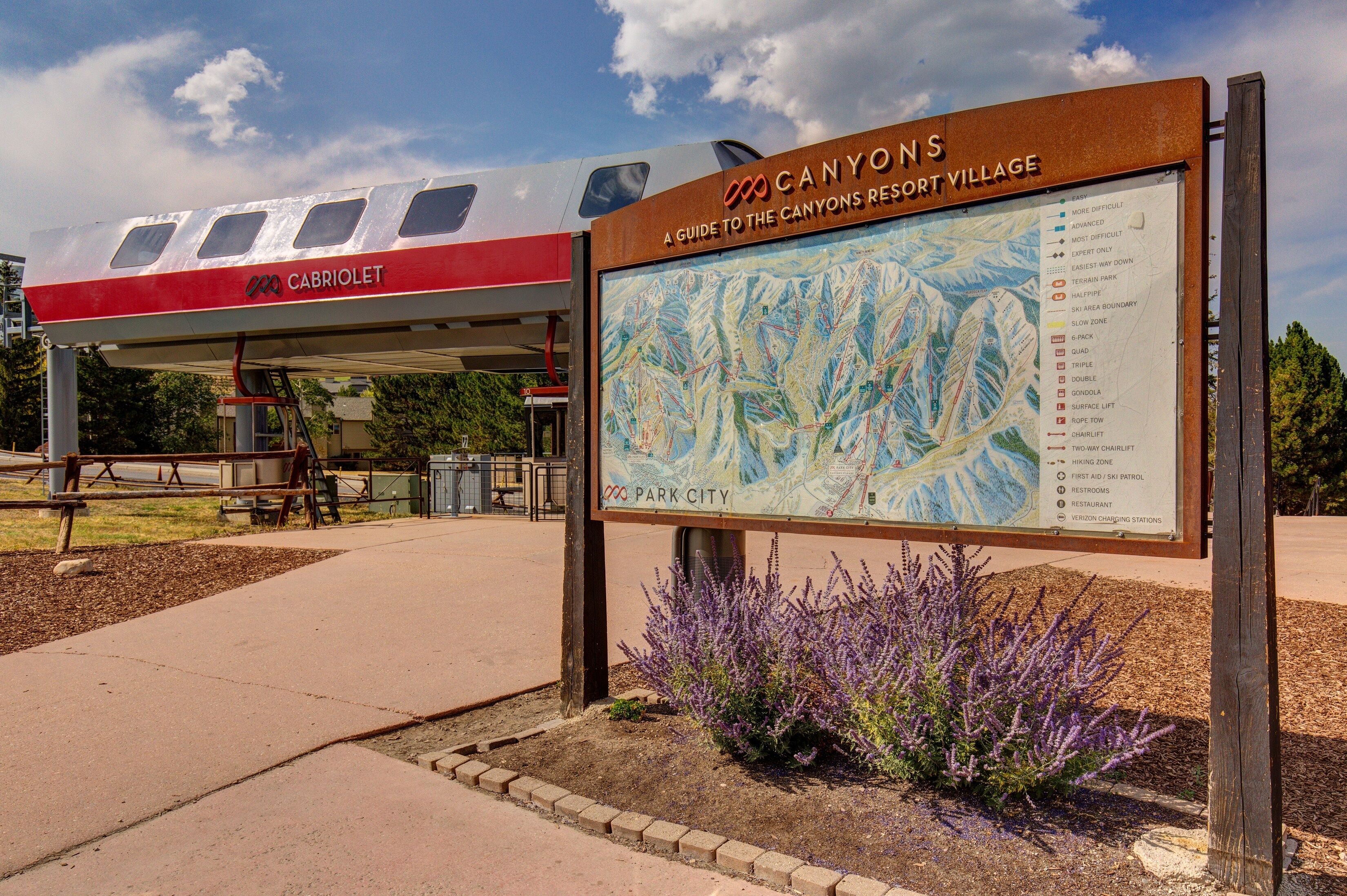 A sign for CANYONS Resort Village with a map and amenities list.