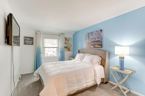 A bedroom with a bed, a bedside lamp, a mirror, and a window with curtains. - Dover Home - 2 Mi to Delaware State University! (Dover)