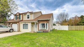 A two-story house with a garage, a front yard, and a wooden fence.