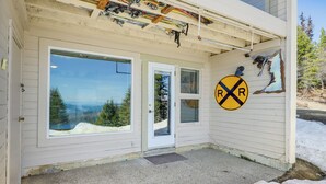 Un bâtiment doté d’une grande fenêtre donnant sur un paysage enneigé, d’une porte et d’un panneau indiquant un passage à niveau.