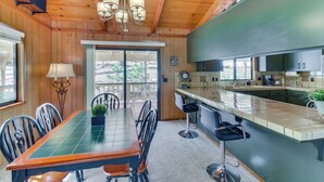 A wooden interior with a dining area, kitchen, and bar. - Cozy Cabin in Pine Mountain Lake Near Yosemite! (Groveland)