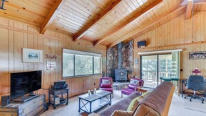 A cozy cabin interior with wooden walls, a stone fireplace, a television, and comfortable seating. - Cozy Cabin in Pine Mountain Lake Near Yosemite! (Groveland)