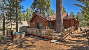 A wooden cabin with a deck, surrounded by pine trees. - Sunrise Pines Cabin | Spa · Near Village (Big Bear Lake)