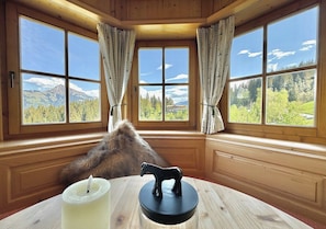 A room with large windows, a fur throw, a candle, and a horse figurine on a table. - Traumhaftes Luxus-Chalet für 8 Personen zwischen Kitzbühel & Ellma (Schattseite)