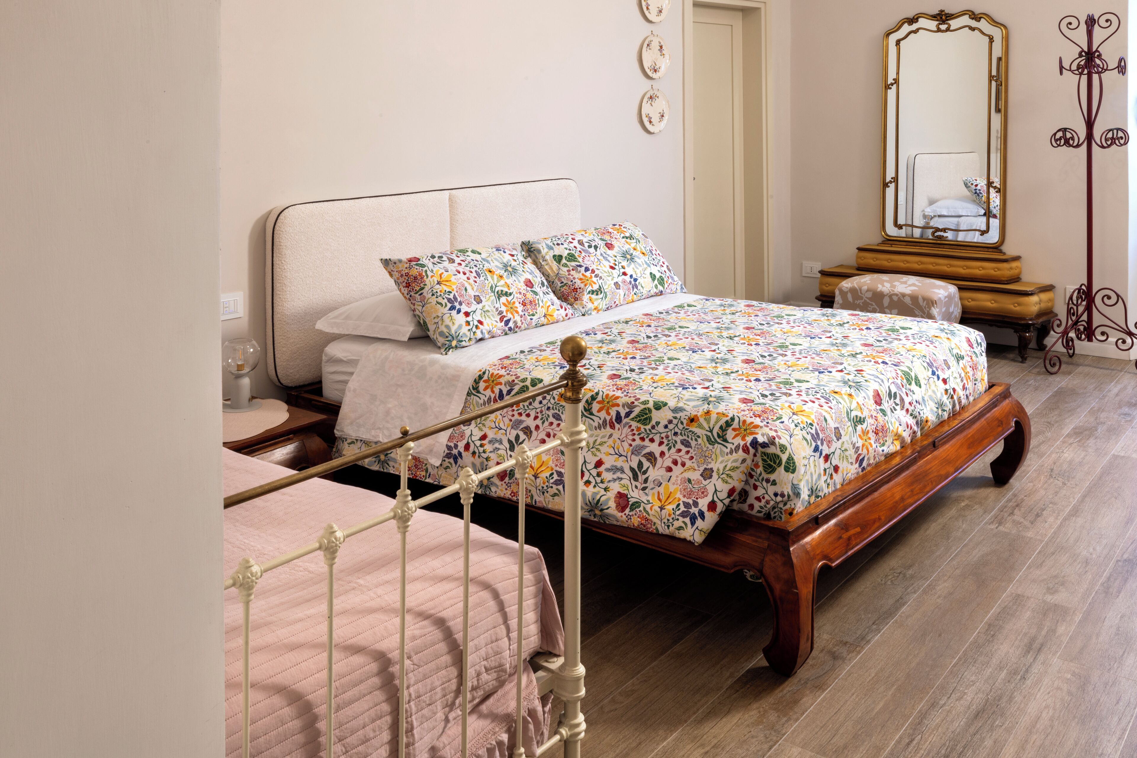 A bedroom with a bed, bedside table, and a mirror.