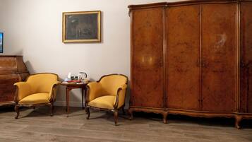 A room with two yellow armchairs, a wooden cabinet, and a small table with items on it.