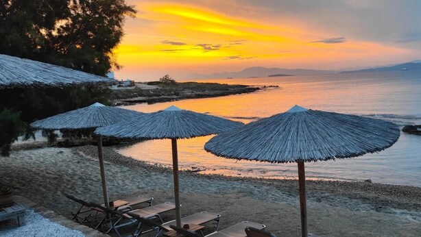 A beach with thatched umbrellas and a view of the sea at sunset. - Sylvia s House at Vagia (Aegina)