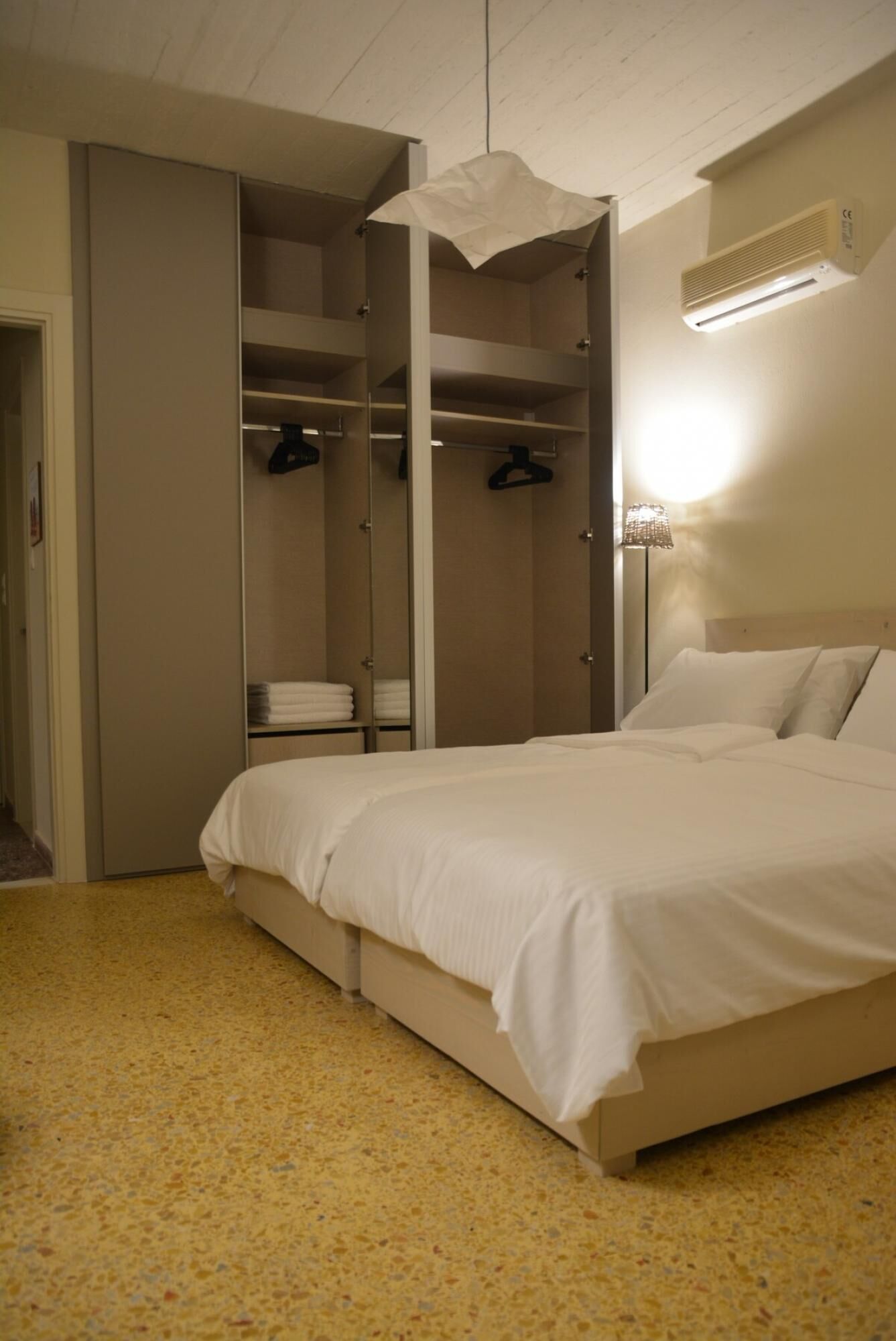 A bedroom with a bed, a walk-in closet, and a wall-mounted heater.