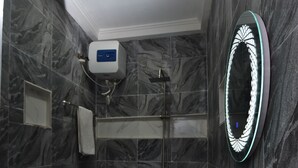 Une salle de bain avec des toilettes, un lavabo et une douche.