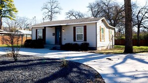 A single-story house with a front porch, a small front yard, and a driveway.