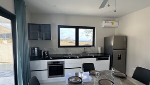Eine moderne Küche mit Essbereich, großen Fenstern und einem Deckenventilator.