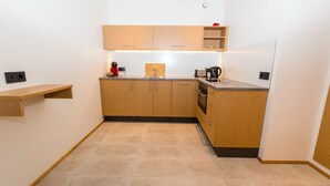 Una cocina compacta con armarios de madera, una encimera y un horno empotrado.