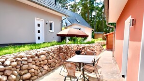 Eine Terrasse mit einer Steinmauer, einem Tisch und Stühlen.