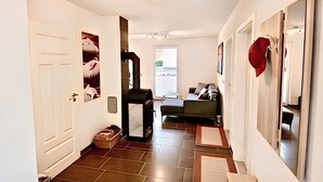Ein Flur mit Tür, einer Bank und einem Sofa.