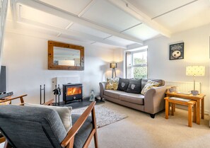 Cozy living room with a comfortable sofa, fireplace, and TV for a relaxing stay.