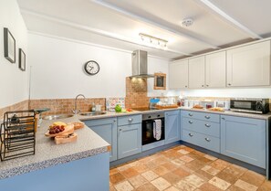 Enjoy cooking in this well-equipped kitchen with an oven, microwave, and stainless steel sink.