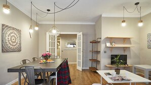 A modern living space with a dining area, a sofa, and a TV. - San Fructuoso ·  - Three Bedroom Apartment, Sleeps 5 (Barcelona)