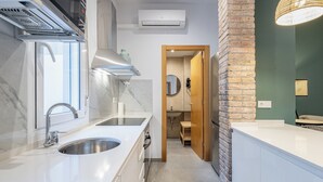 A modern kitchen with a stainless steel sink, a built-in oven, and a range hood. - TIinent Flomesta 2110 (Barcelona)