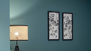 A modern living room with a white sofa, a round dining table, and a floor lamp. There are two framed floral artworks on the wall. - TIinent Flomesta 2110 (Barcelona)