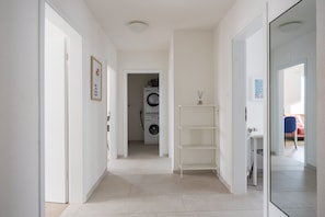 Enter a clean hallway leading to a convenient laundry area with a washing machine and dryer.