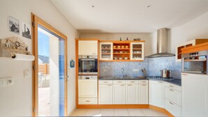 A modern kitchen with white cabinets, a granite countertop, and a stainless steel range hood. - Sea view, 200m from the beach, house for 9 (Plovan)