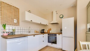 A modern kitchen with white cabinets, a dishwasher, an oven, and a refrigerator. - Saint-Vincent-sur-Jard, house for 5 (Saint-Vincent-sur-Jard)