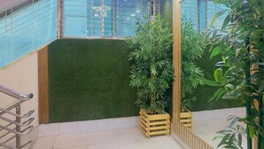 Een modern interieur met een decoratief plafond, een verticale groene wand en potplanten.
