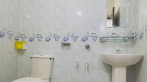 Een badkamer met toilet, wastafel en douche.