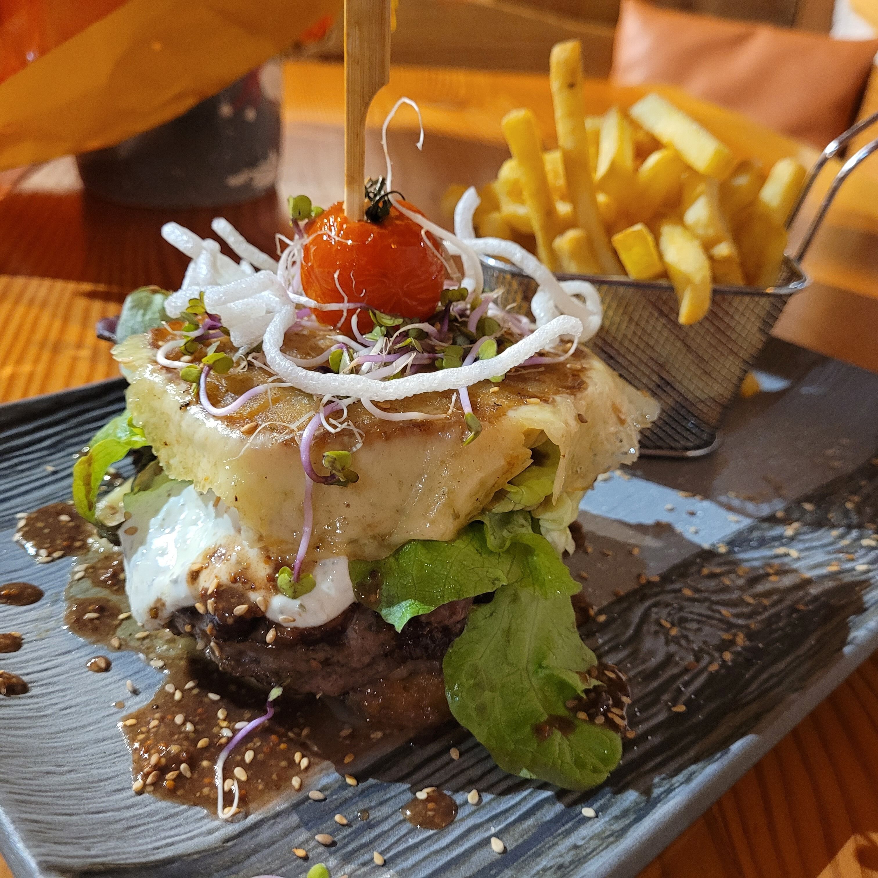 A plate with a burger, fries, and a drink.