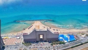 Un grand hôtel doté d’une cour intérieure, d’un espace piscine et offrant une vue sur la plage.