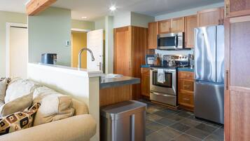 A compact kitchen with wooden cabinets, stainless steel appliances, and a built-in oven.