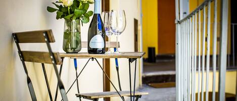 Une table avec une bouteille de vin, un verre et un vase de fleurs.