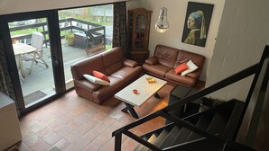 Ein Wohnzimmer mit einem braunen Ledersofa, einem weißen Couchtisch und einem Holzschrank.