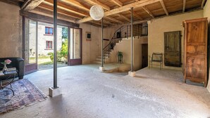Una habitación amplia con techo alto, una escalera y vistas al exterior.
