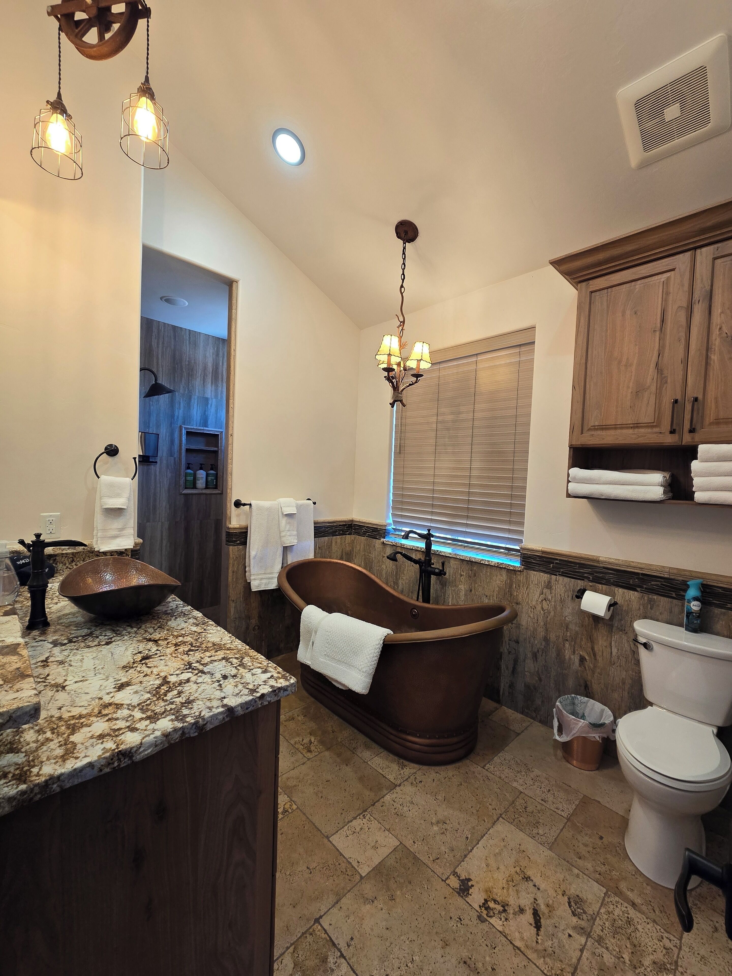 Un baño con una bañera independiente, un lavabo, un inodoro y un tocador con espejo.