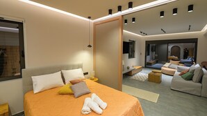 Une chambre d’hôtel moderne avec un grand lit, un canapé et une petite table.