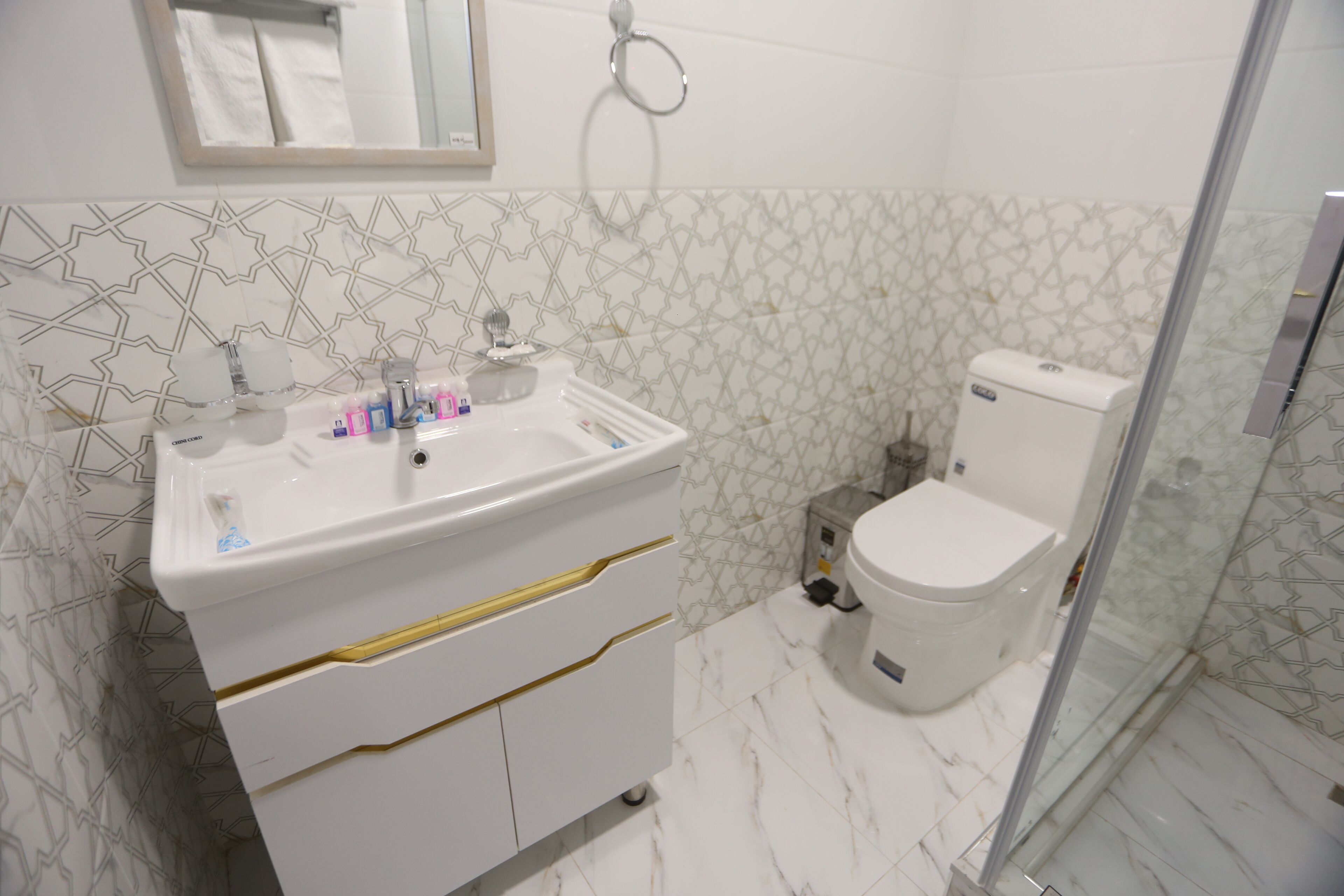 A bathroom with a white sink, a toilet, and a shower area.