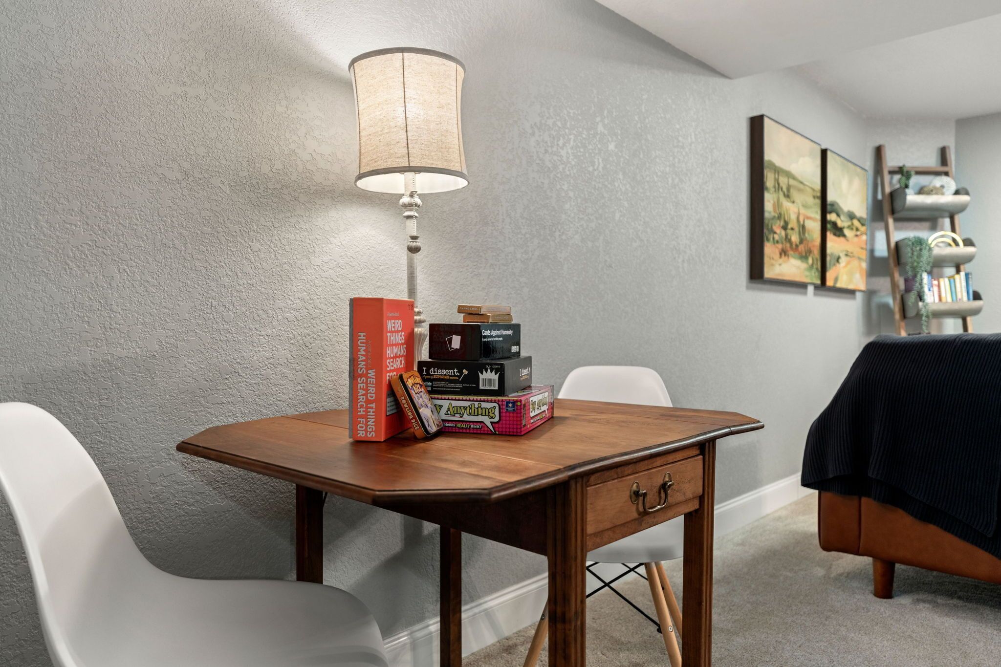 Ein Essbereich mit einem Holztisch, einer Lampe und Büchern.