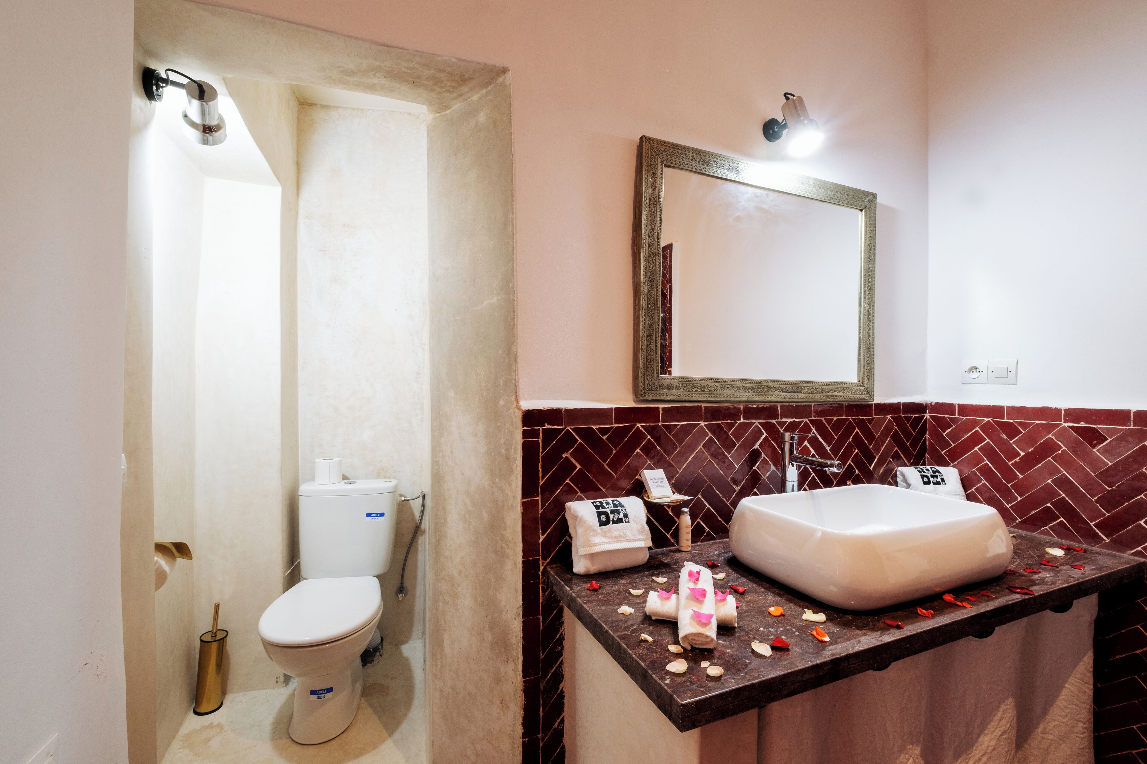 Un baño con inodoro, lavamanos y espejo.