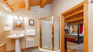 A bathroom with a sink, mirror, and shower. - Dog Friendly Lodge w/ Hot Tub & Views (McHenry)