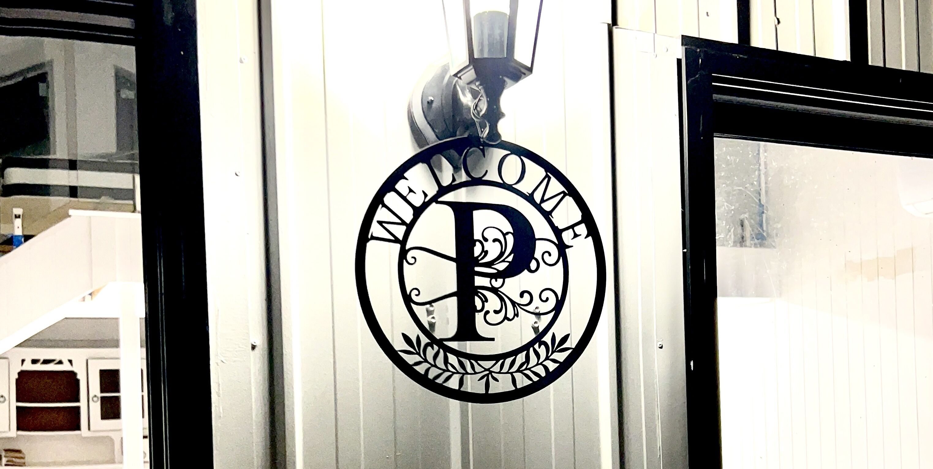 Logotipo circular con una 'P' estilizada y el texto 'WELCOME' en una puerta.