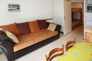 A compact living space with a sofa, a dining table with chairs, and a kitchenette area. - 10m from ski slopes, 3rd floor, view mountain, balcony, tv, ski locker, 28m², Les Orres (Les Orres)