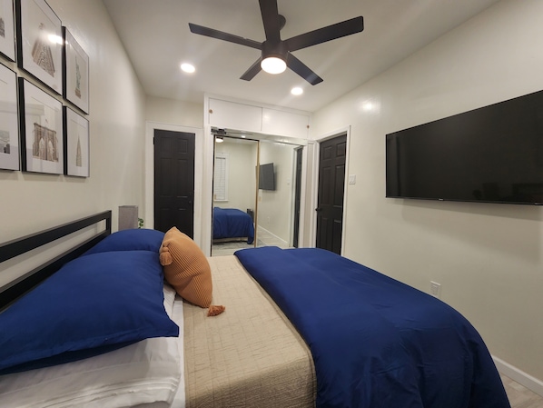 Relax in a stylish room with a ceiling fan, flat-screen TV, and comfortable bed.